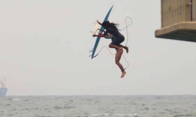 Filmstill aus "Chicks on Boards": Surferin beim Sprung (© Labo M.)