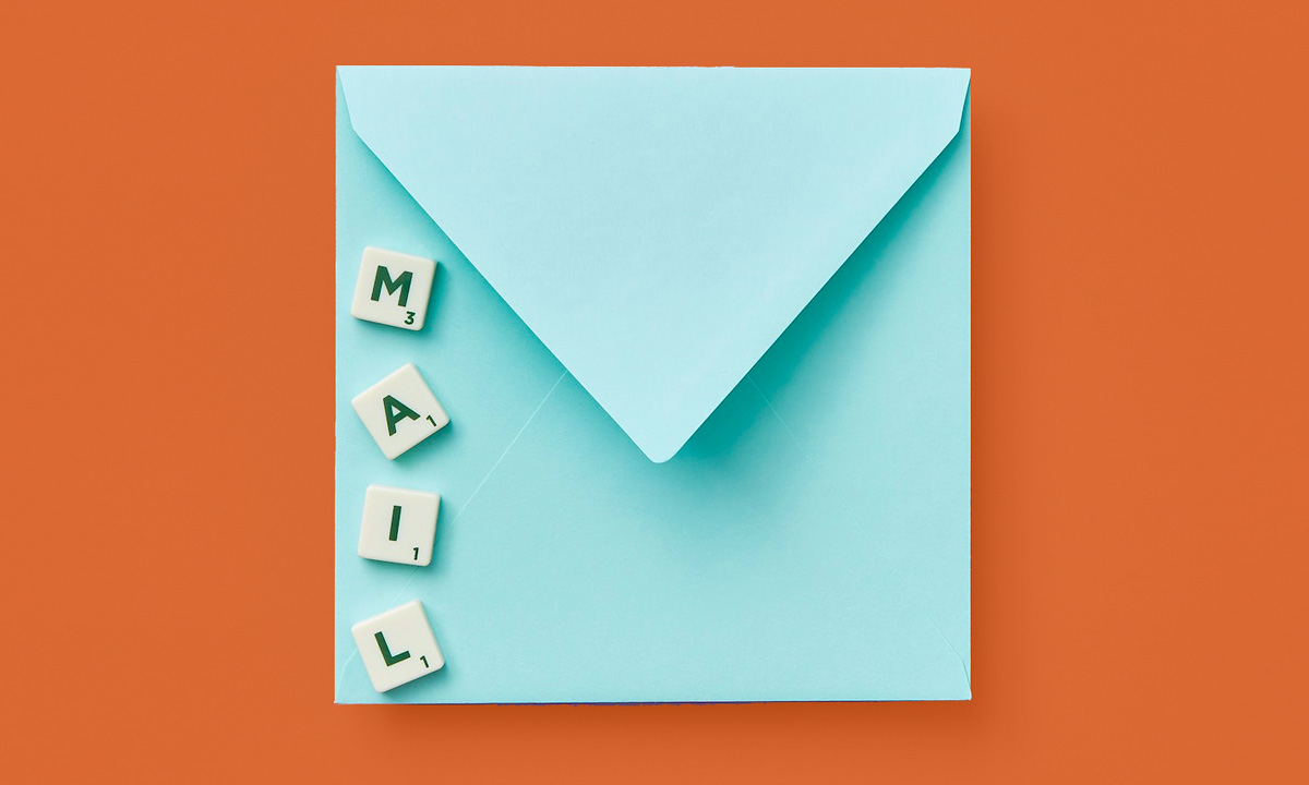 Türkiser Briefumschlag auf orangenem Hintergrund. Auf dem Briefumschlag steht das Wort Mail mit Scrabble-Buchstaben gelegt (Foto: DS Stories/Pexels)